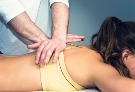 A Chiropractor for Oak Brook IL making spinal adjustments to a patient's back