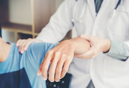 A chiropractor helping a patient with shoulder pain, as a part of Alternative Medicine Clarendon Hills