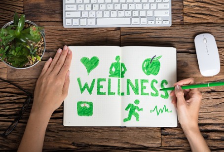 A notebook with a green marker writing wellness in it, representing Integrative Medicine in Downers Grove IL