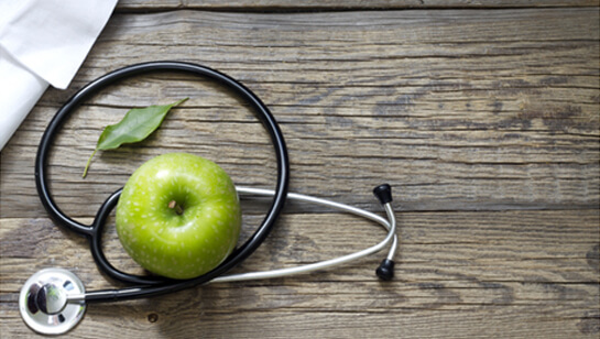 Apple and stethoscope representing Natural Medicine Doctor in Clarendon Hills IL